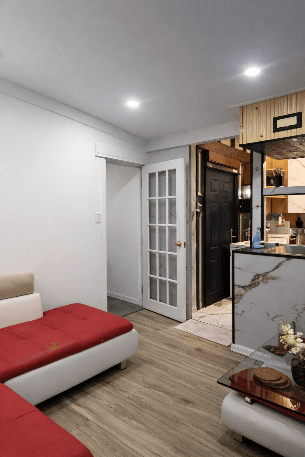 Living room view showing bright lighting and open layout.